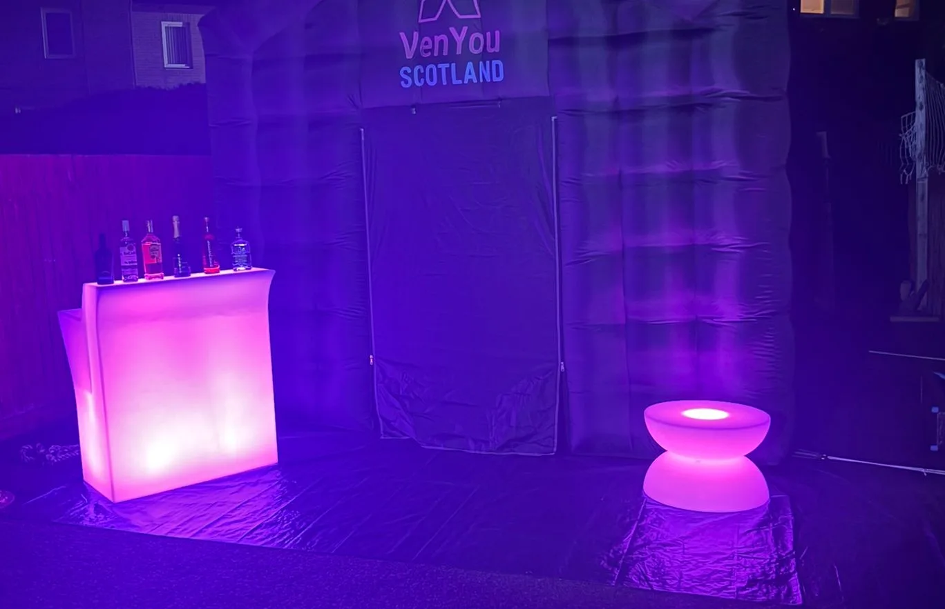Pink LED glow bar and table in front of a VenYou Scotland branded tent at night
